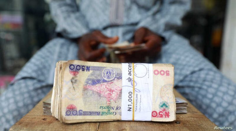 A money changer counts Nigerian currency notes for a customer in Nigeria's commercial capital, Lagos, March 16, 2020